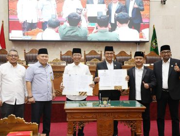 Wali Kota Batam, Amsakar Achmad, bersama pimpinan dan anggota DPRD Batam menunjukkan dokumen pengesahan Perda PSU usai Rapat Paripurna di Ruang Sidang Utama DPRD Kota Batam, Rabu (24/6/2026). 