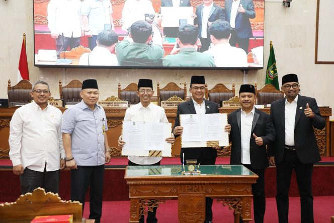 
					Wali Kota Batam, Amsakar Achmad, bersama pimpinan dan anggota DPRD Batam menunjukkan dokumen pengesahan Perda PSU usai Rapat Paripurna di Ruang Sidang Utama DPRD Kota Batam, Rabu (24/6/2026). 