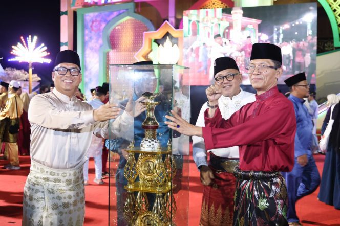 
					Wakil Gubernur Kepri sekaligus Ketua LPTQ Nyanyang Haris Pratamura didampingi Wali Kota Tanjungpinang Lis Darmansyah menyerahkan tropi juara umum MTQ XII Tingkat Provinsi Kepulauan Riau kepada Wali Kota Batam Amsakar Achmad, Kamis (9/7/2026). 