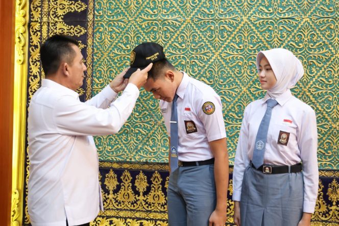 
					Gubenrur Kepri Ansar Ahmad memasangkan topi Calon Paskibraka kepada Muhammad Salman Farisi dan Raudah Mabrura, perwakilan Kepri Calon Pasukan Pengibar Bendera Pusaka (Paskibraka) Nasional Tahun 2026 di Gedung Daerah Tanjungpinang, Senin (13/7/2026). 