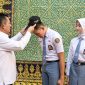 Gubenrur Kepri Ansar Ahmad memasangkan topi Calon Paskibraka kepada Muhammad Salman Farisi dan Raudah Mabrura, perwakilan Kepri Calon Pasukan Pengibar Bendera Pusaka (Paskibraka) Nasional Tahun 2026 di Gedung Daerah Tanjungpinang, Senin (13/7/2026). 