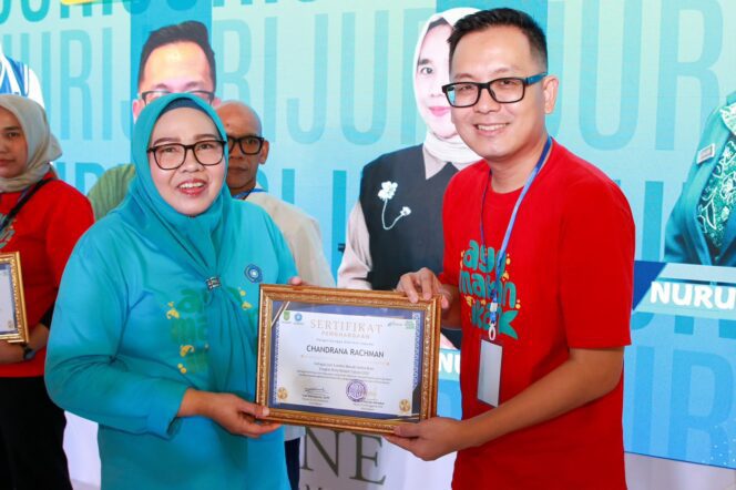 
					Ketua TP-PKK Batam, Erlita Amsakar, menyerahkan piagam penghargaan kepada juri Lomba Masak Serba Ikan Tingkat Kota Batam Tahun 2026 di One Batam Mall, Rabu (5/8/2026). 